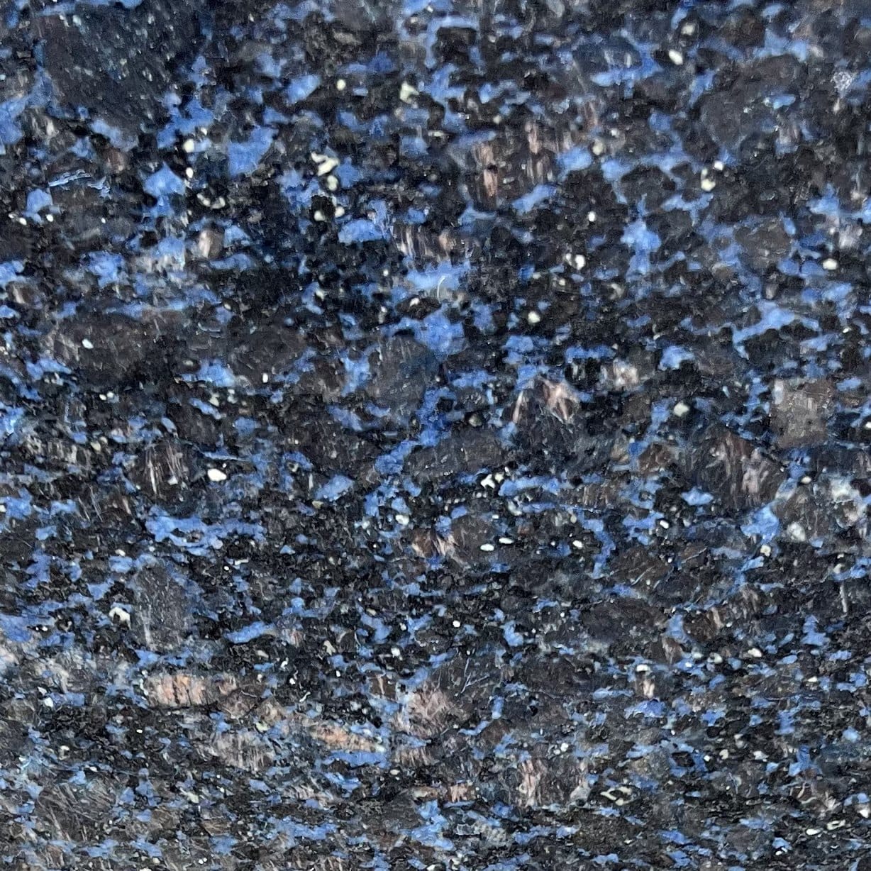 Close-up of dark granite with blue patches and light specks